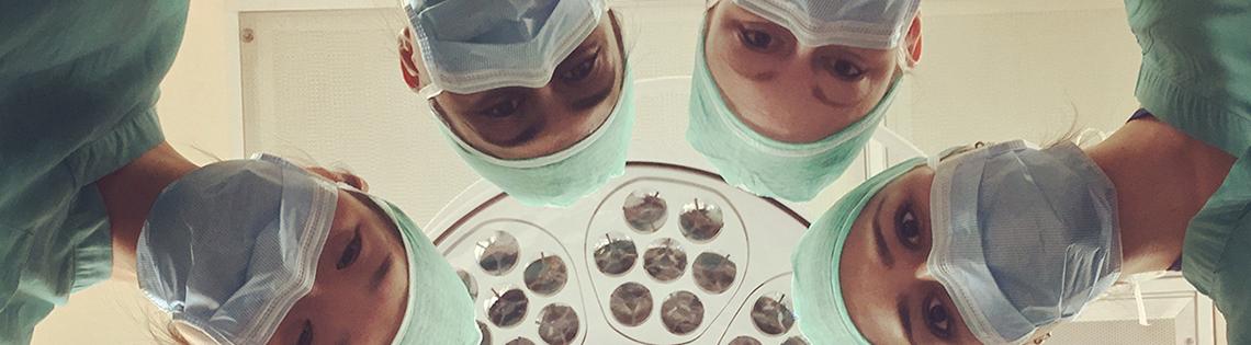 Goff and seven female clinical fellows in an operating wearing scrubs