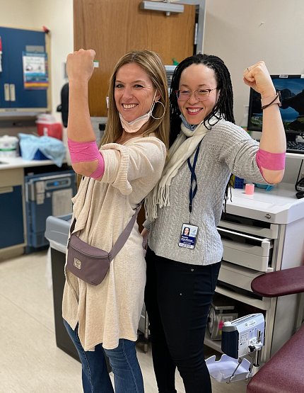 West-Mitchell (r) and a friend flex their arms to show the pink bandages wrapped around their elbows.