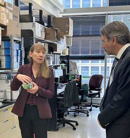 Dr. Andrews holds 3D virus model while talking with Plescia in VRC lab.