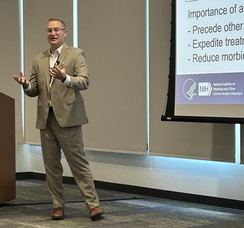 Levy stands talking, hands out, explaining his research.