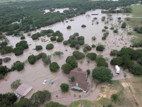 Aerial view of a neighborhood under water, with houses and cars submerged