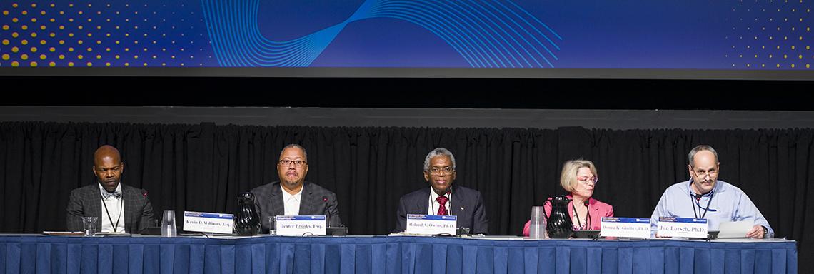 Five participants sit on a panel