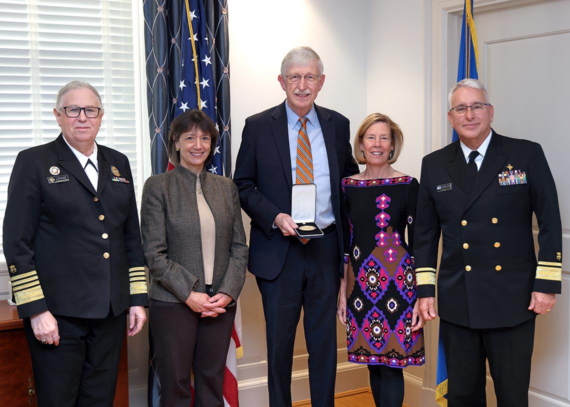 Group photo, with Collins in the middle, smiling, holding his medal