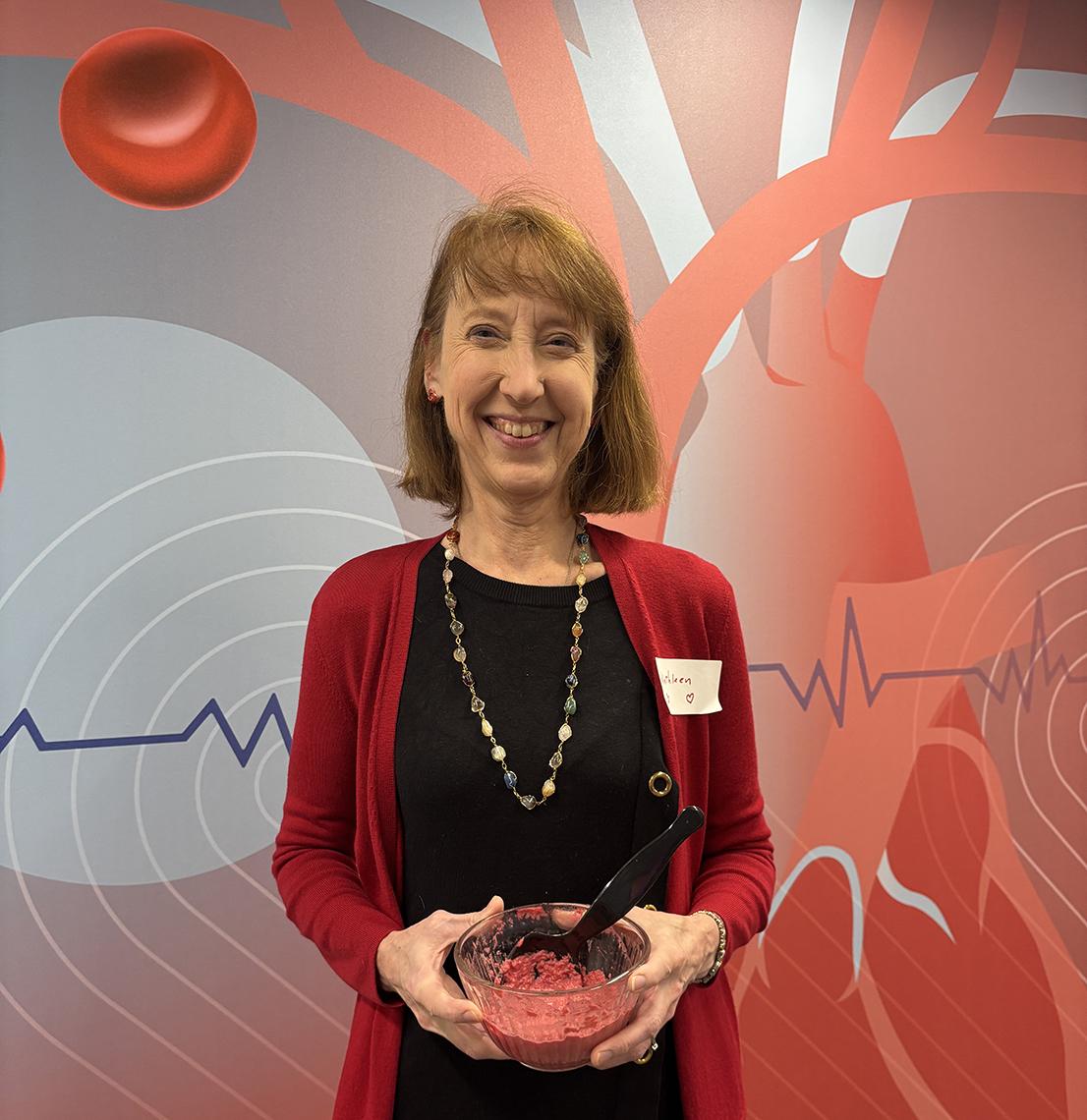 Fenton in red cardigan holds bowl of food