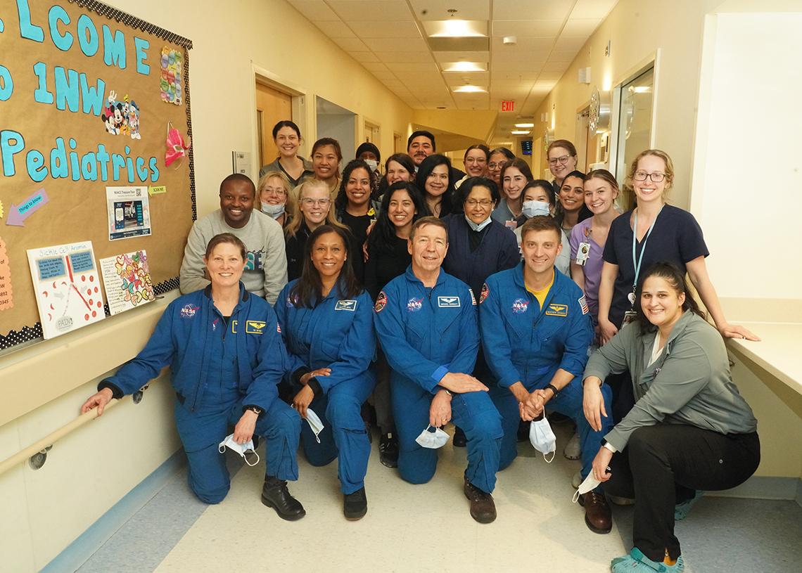 In the hallway of pediatric wing of CC, investigators pose with the 4 astronauts.