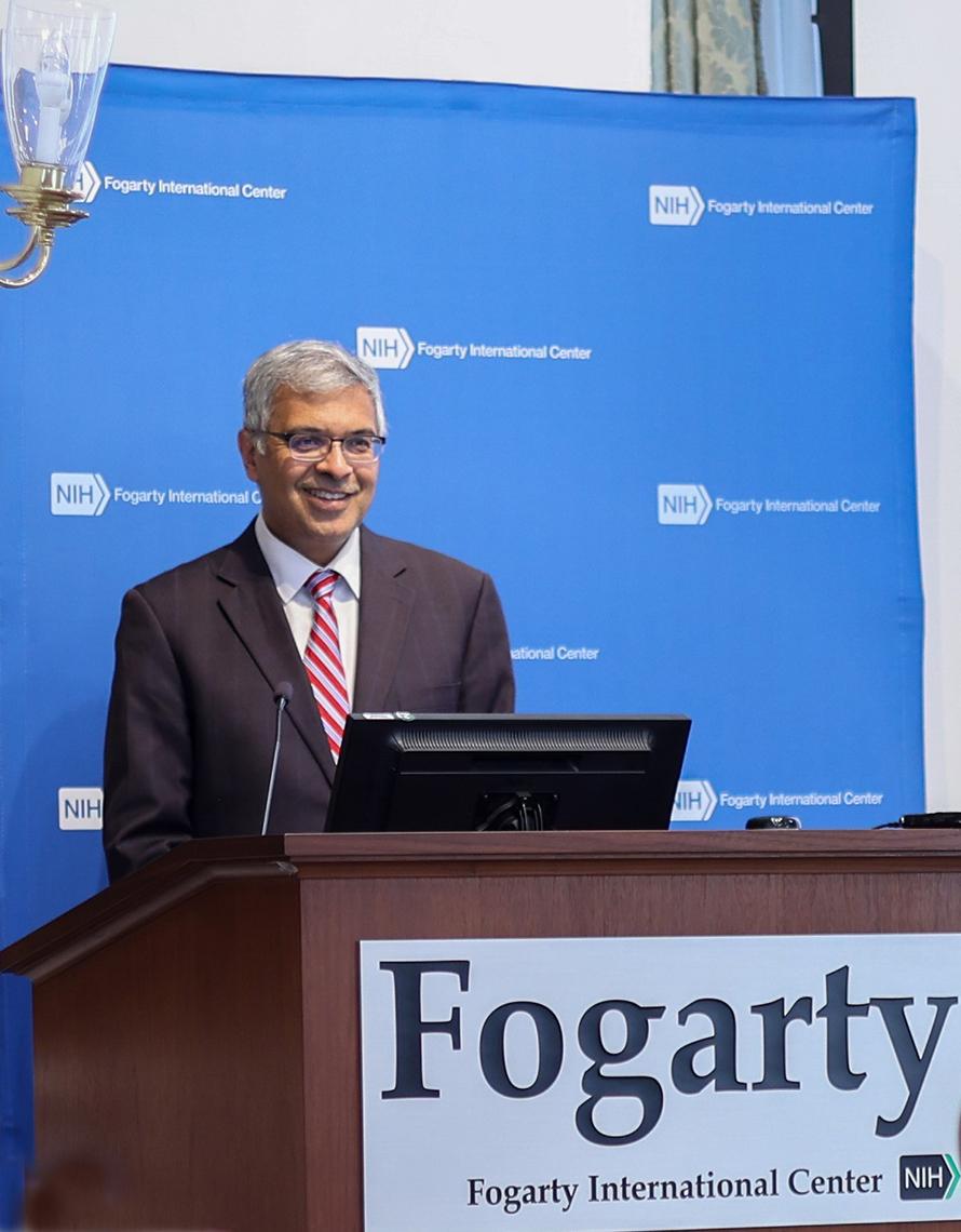 Dr. Jay Bhattacharya at Fogarty podium with blue NIH backdrop