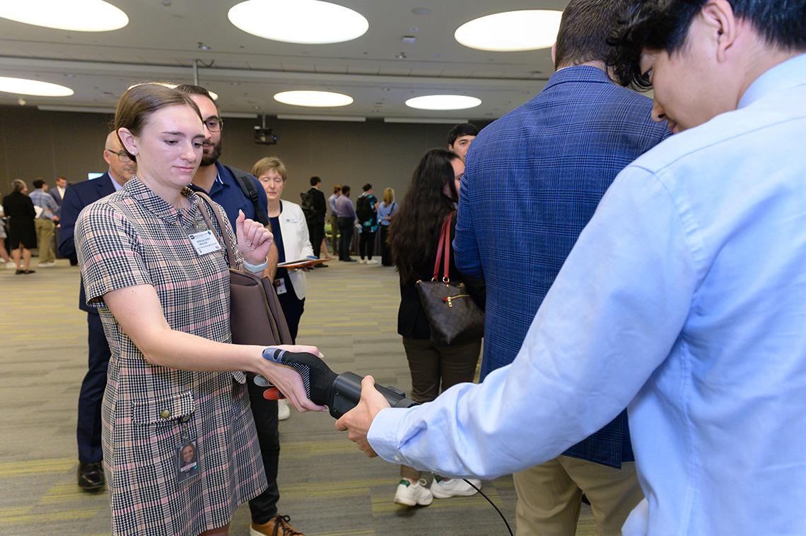 A researcher shakes hands with a robotic arm