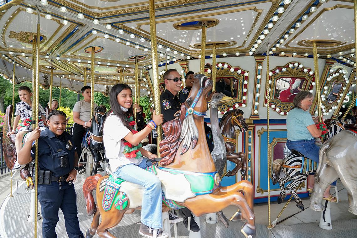 Inn residents and officers ride a carousel 